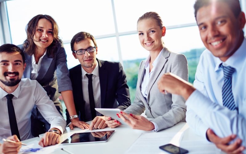 Elegant co-workers looking at camera during meeting in office